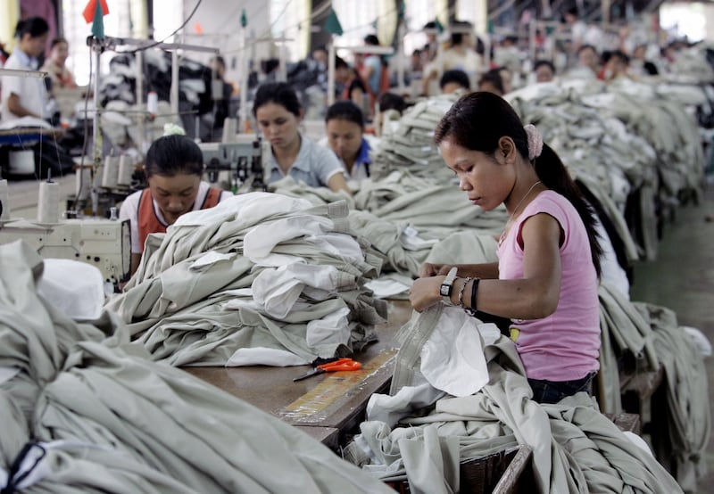 Factory workers assemble garments to be exported abroad on the outskirts of the Laotian capital Vientiane May 2, 2006. Rising prices and falling real wages are prompting many people to work abroad.