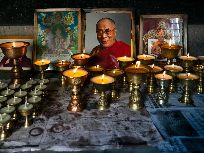Butter lamps are seen lit in front of Dalai Lama portrait, Jan. 8, 2025, in remembrance of those who lost their lives in the recent earthquake, at a Tibetan camp in Lalitpur, Nepal.