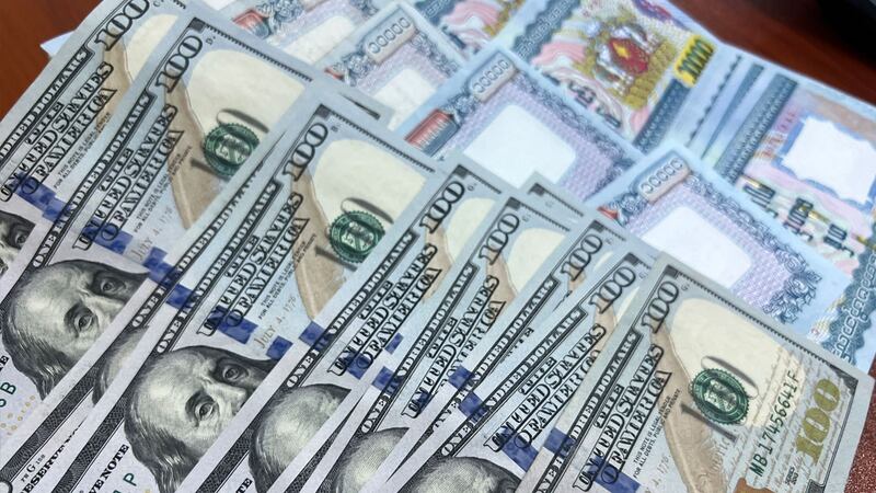 အမေရိကန်ဒေါ်လာနှင့် မြန်မာကျပ်ငွေများကို တွေ့ရစဉ်။ (Photo: RFA)