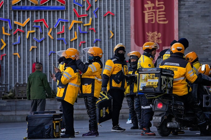 2024年1月5日,美团外卖员在北京一个街区聚集。(美联社)